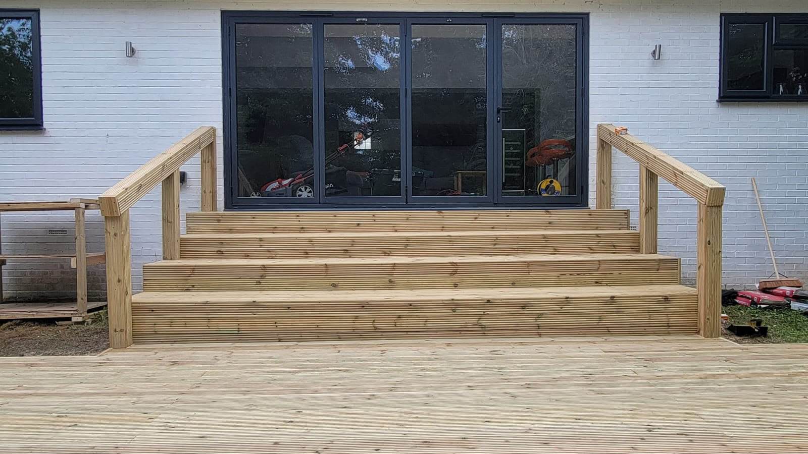 Finished timber decking and steps leading up to bi-fold doors